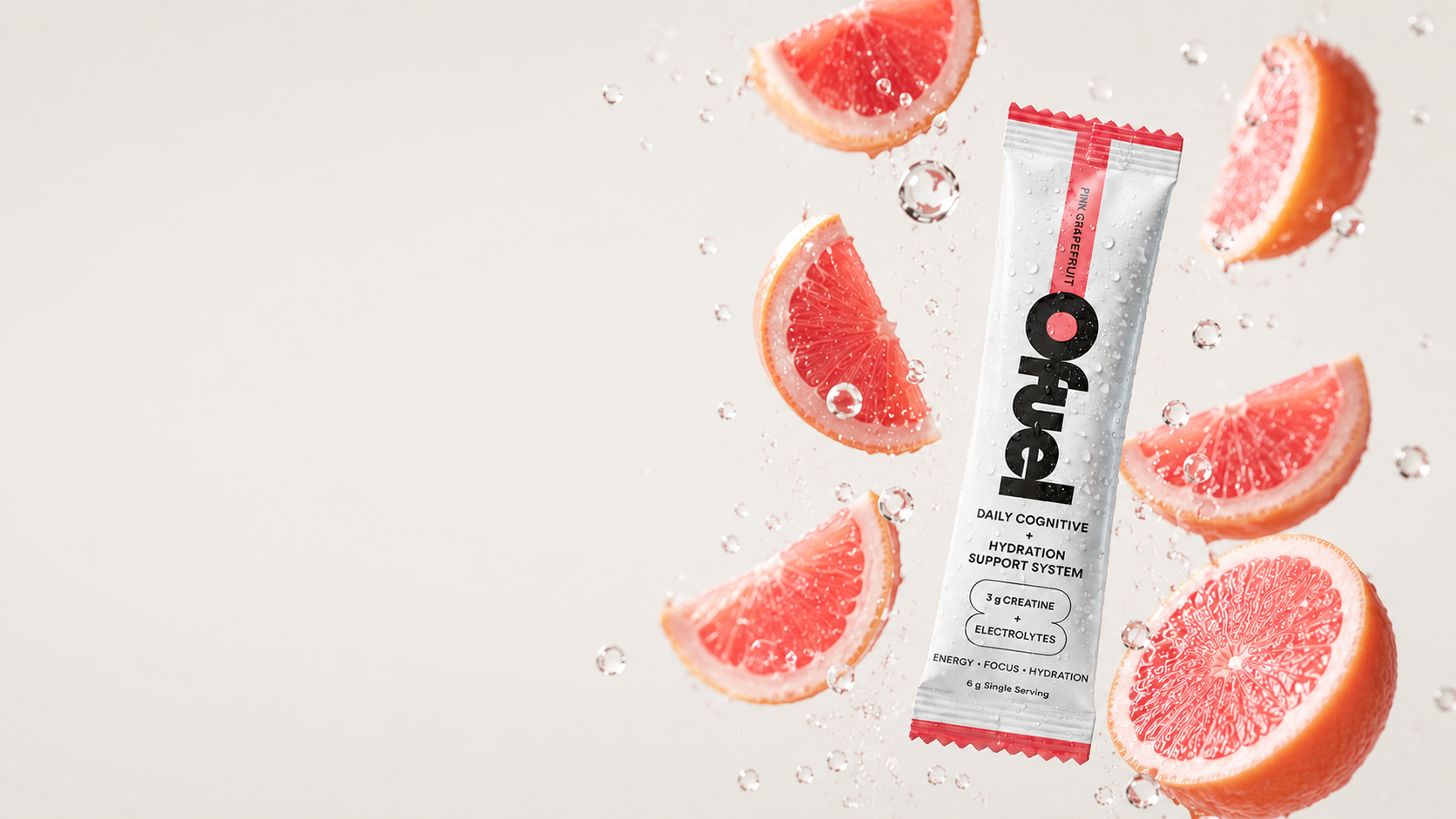 An Ofuel Pink Grapefruit sachet floating among grapefruit slices and water droplets.