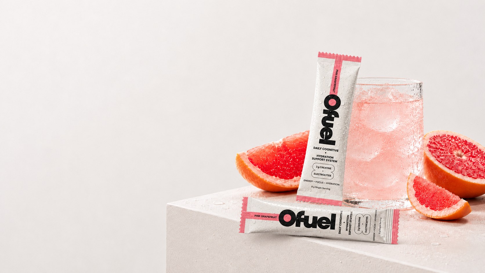 Ofuel Pink Grapefruit sachets beside a glass of mixed Ofuel