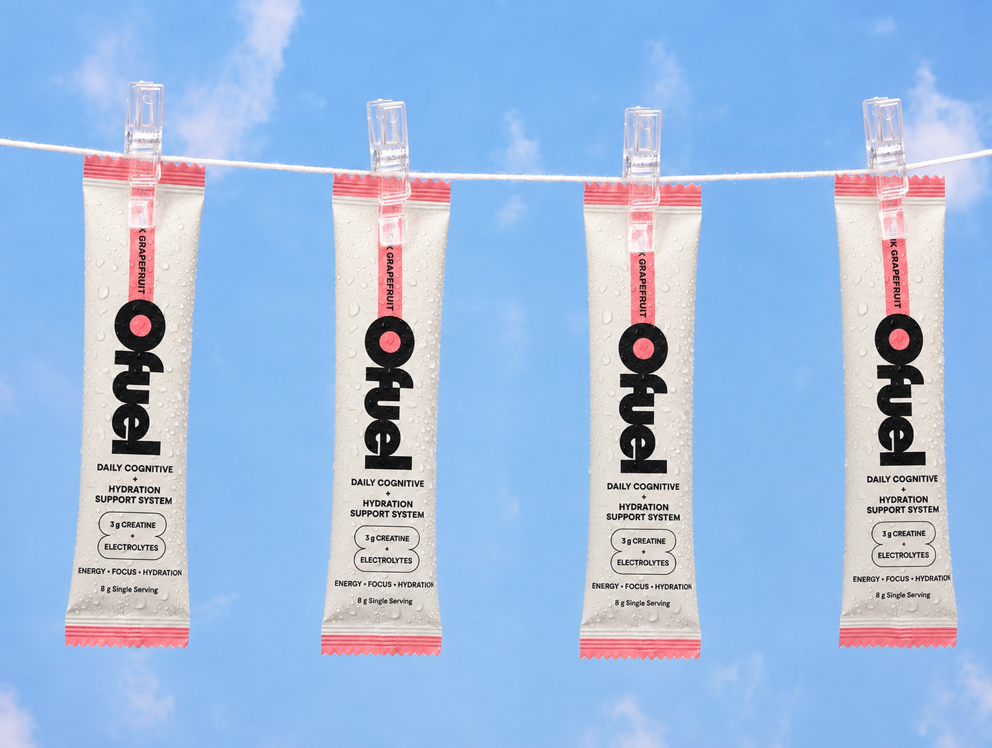 Four Ofuel Pink Grapefruit sachets pegged to a washing line against a blue sky.